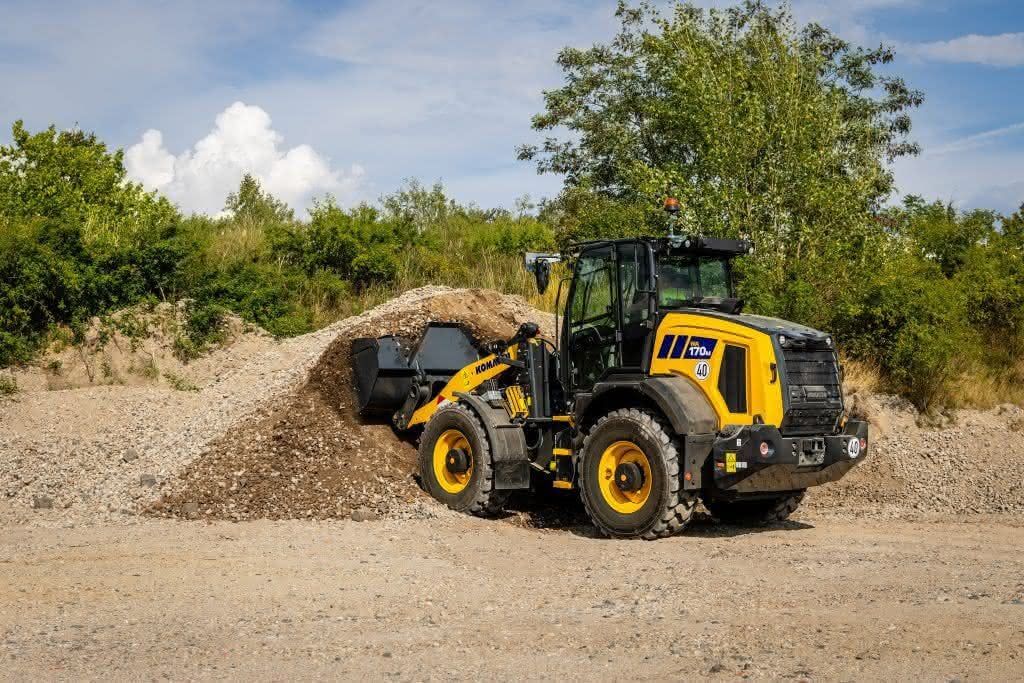 Der SK715-8 von Komatsu Ein SK715-8 von Komatsu lädt auf einer Halde Material ab