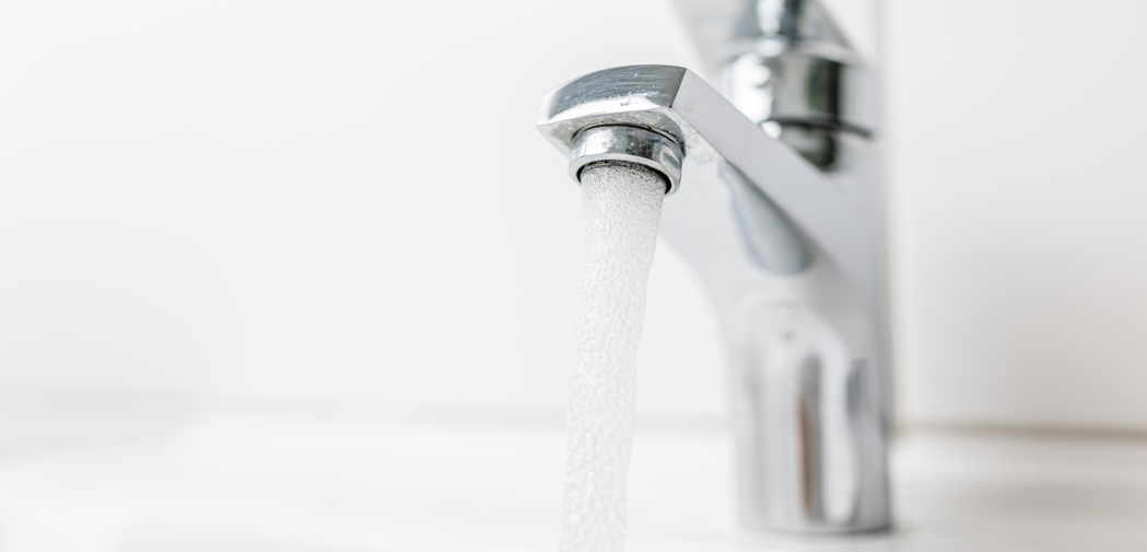 Wasser läuft aus einem Wasserhahn. Wasser läuft aus einem Wasserhahn.
