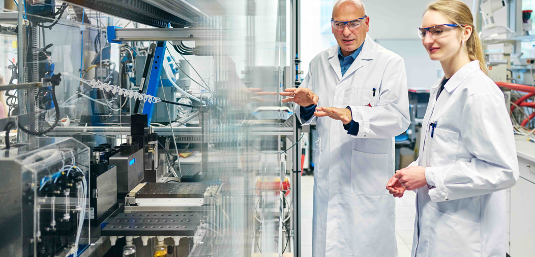 Graduiertenkolleg der Universitäten Jena und Bayreuth Prof. Dr. Ulrich S. Schubert und Dr. Natalie Göppert von der Universität Jena vor einem Syntheseroboter zur automatischen Durchführung von Copolymerisationen.
