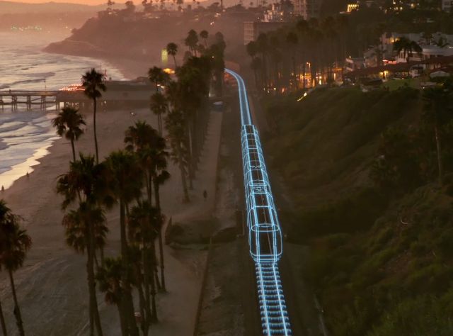 Autodesk wird offizielle Design- und Make-Plattform der Olympischen und Paralympischen Spiele LA28 Ein von Autodesk mit künstlicher Intelligenz hergestelltes 3D-Modell eines Zuges in Los Angeles fährt auf einer Gleisstrecke am Strand