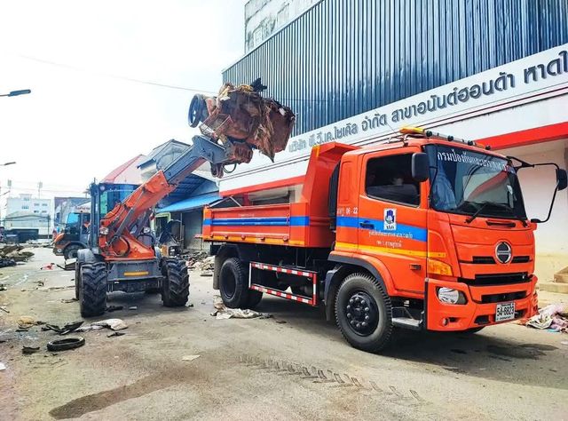 Ein Paus-Lader belädt einen Muldenkipper in Thailand