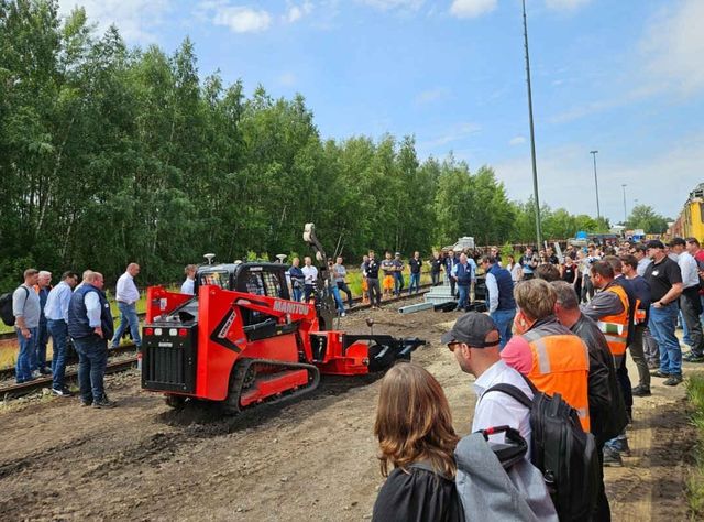 Manitou auf dem DB Infrastruktur Workshop Nord Ein Kettenlader von Manitou demonstriert vor zahlreichen Zuschauern die Verlegung von Glasfaserkabeln im Erdreich.