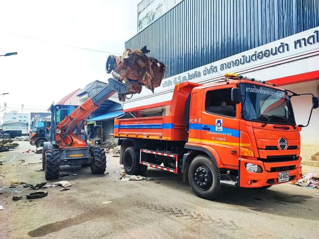 Ein Paus-Lader belädt einen Muldenkipper in Thailand