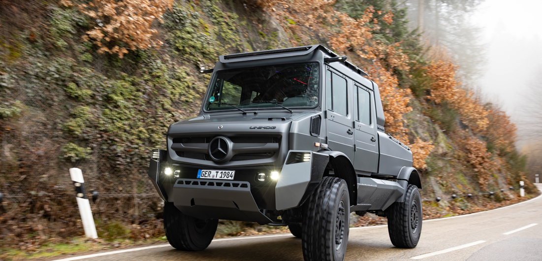Unimog Berg Der Luxus-Unimog auf einer feuchten Gebirgsstraße im Herbst.