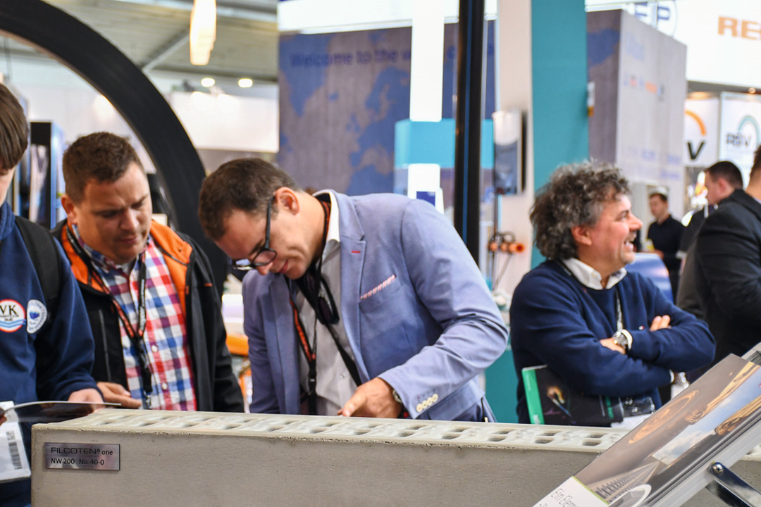 Besucher aur einer Messe begutachten Produkte von BG-Graspointner