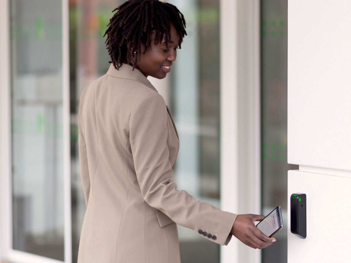 Access solution for complex building openings: Card reader from Assa Abloy with integrated relay Employee uses Assa Abloy card reader to open a company door