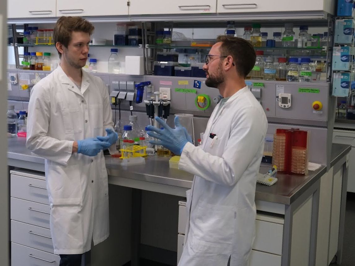 Der Biochemiker Patrick Penndorf (l.) im Gespräch mit Jakob Sprague (Abteilung Mikrobielle Pathogenitätsmechanismen). Forschung umweltfreundlicher gestalten. Der Biochemiker Patrick Penndorf (l.) im Gespräch mit Jakob Sprague (Abteilung Mikrobielle Pathogenitätsmechanismen). Sie besprachen sich zu Möglichkeiten zur Protokolloptimierung und den Einsatz nachhaltiger Lösungen im Labor.