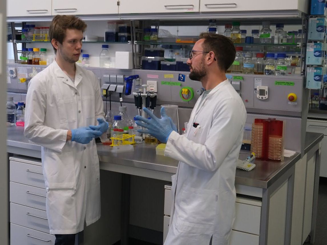 Der Biochemiker Patrick Penndorf (l.) im Gespräch mit Jakob Sprague (Abteilung Mikrobielle Pathogenitätsmechanismen). Forschung umweltfreundlicher gestalten. Der Biochemiker Patrick Penndorf (l.) im Gespräch mit Jakob Sprague (Abteilung Mikrobielle Pathogenitätsmechanismen). Sie besprachen sich zu Möglichkeiten zur Protokolloptimierung und den Einsatz nachhaltiger Lösungen im Labor.