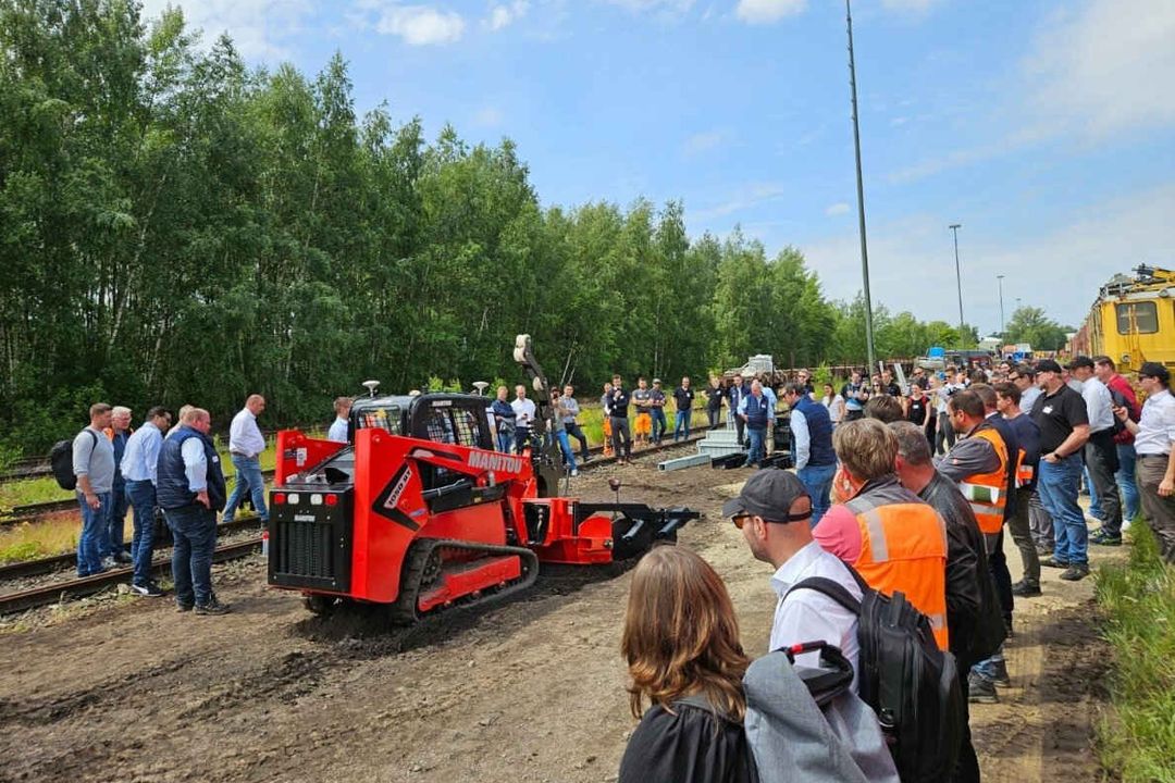 Manitou auf dem DB Infrastruktur Workshop Nord Ein Kettenlader von Manitou demonstriert vor zahlreichen Zuschauern die Verlegung von Glasfaserkabeln im Erdreich.