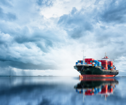 Containerschiff mit dunkel bewölktem Himmel