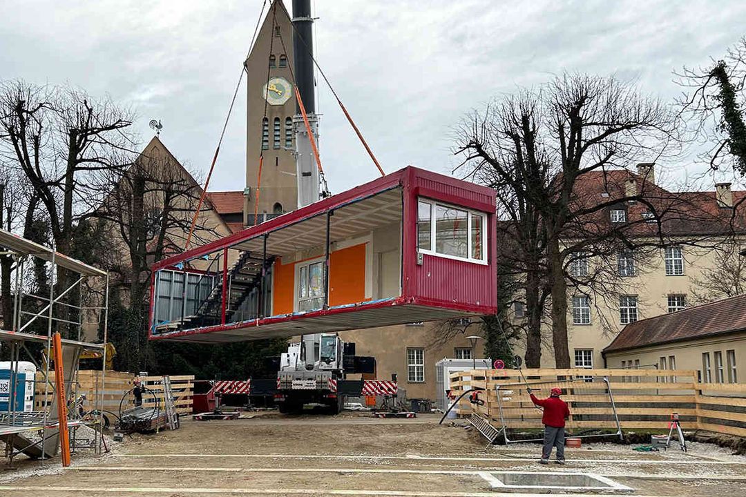 Ein Kran von BKL hebt einen Container auf das Areal in München