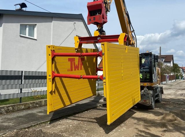 Verbaugreifer Ein TWF-Verbaugreifer, an dem Einstellboxen für den Straßenbau hängen