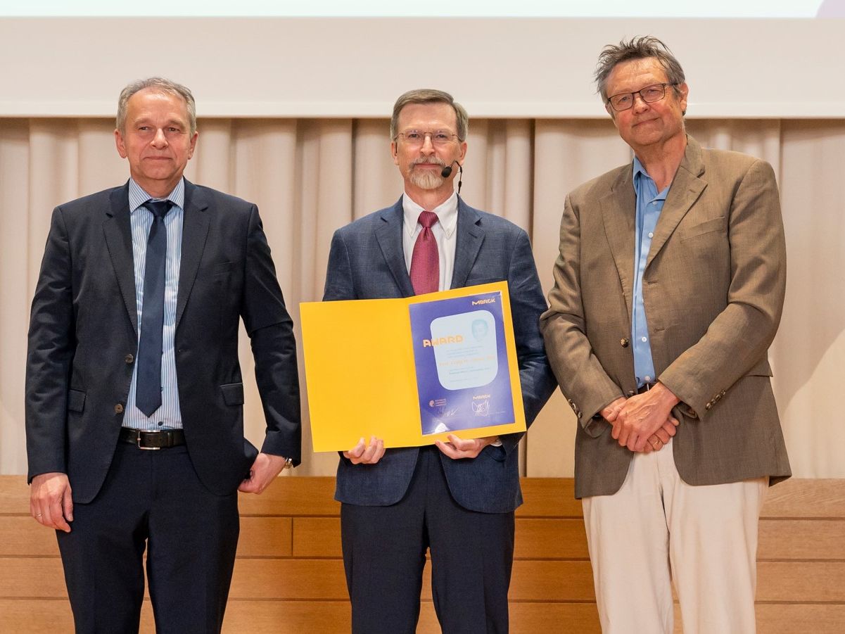Ulrich Betz und Professor Felix Hausch vom Fachbereich Chemie der TU Darmstadt überreichten Craig M. Crews Auszeichnung Ulrich Betz und Professor Felix Hausch vom Fachbereich Chemie der TU Darmstadt überreichten Craig M. Crews die Auszeichnung