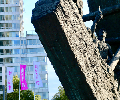 Evonik Firmengebäude im Hintergrund mit Statue im Vordergrund, die einen Arbeiter Bergbau darstellt