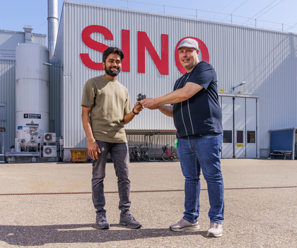 Mano Raj Dhanalakshmi Veeraraj und Joan Vila-Comamala forschen beide am PSI Zentrum für Photonenforschung. Hier stehen sie mit der achromatischen Neutronenlinse vor der Schweizer Spallations-Neutronenquelle SINQ.