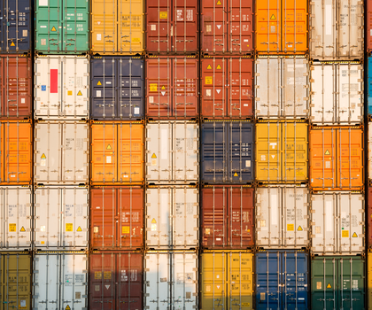 Bunte Container übereinandergestapelt füllerm das gesamte Bild aus. In der Höhe sind es 5 Container, in der Breite neun. Symbolbild für die Stimmung in der Industrie.