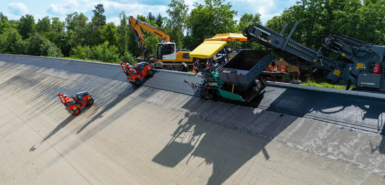 Wirtgen Group Maschinen überzeugen als Gesamtlösung mit besonderem Augenmerk auf die beiden Hamm Walzen, die an der Schräge präzise verdichten. Wirtgen Group Maschinen überzeugen als Gesamtlösung mit besonderem Augenmerk auf die beiden Hamm Walzen, die an der Schräge präzise verdichten.