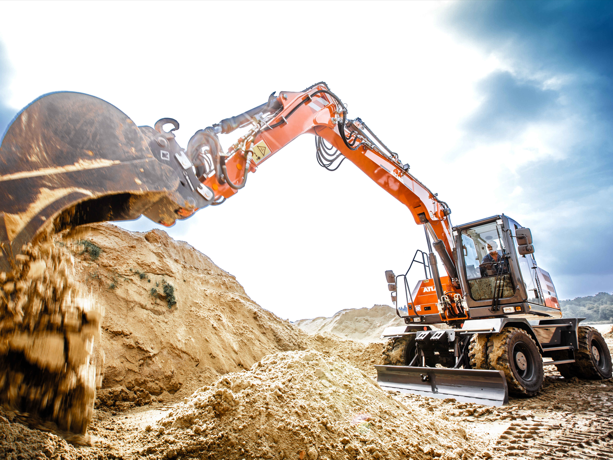 Ein neuer Mobilbagger 185W entlädt Sand aus seinem großen Baggerlöffel