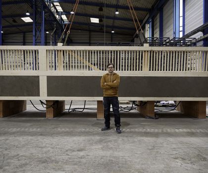 Julian Trummer vor einer Lehm-Holz-Massivdecke in einer weitläufigen Lagerhalle.