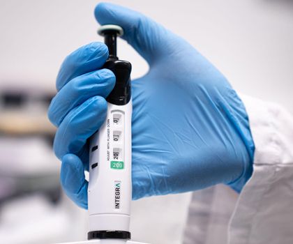 Ergonomisches Pipettieren EVOLVE-Pipette von Integra in der Hand eines Labor-Mitarbeitenden