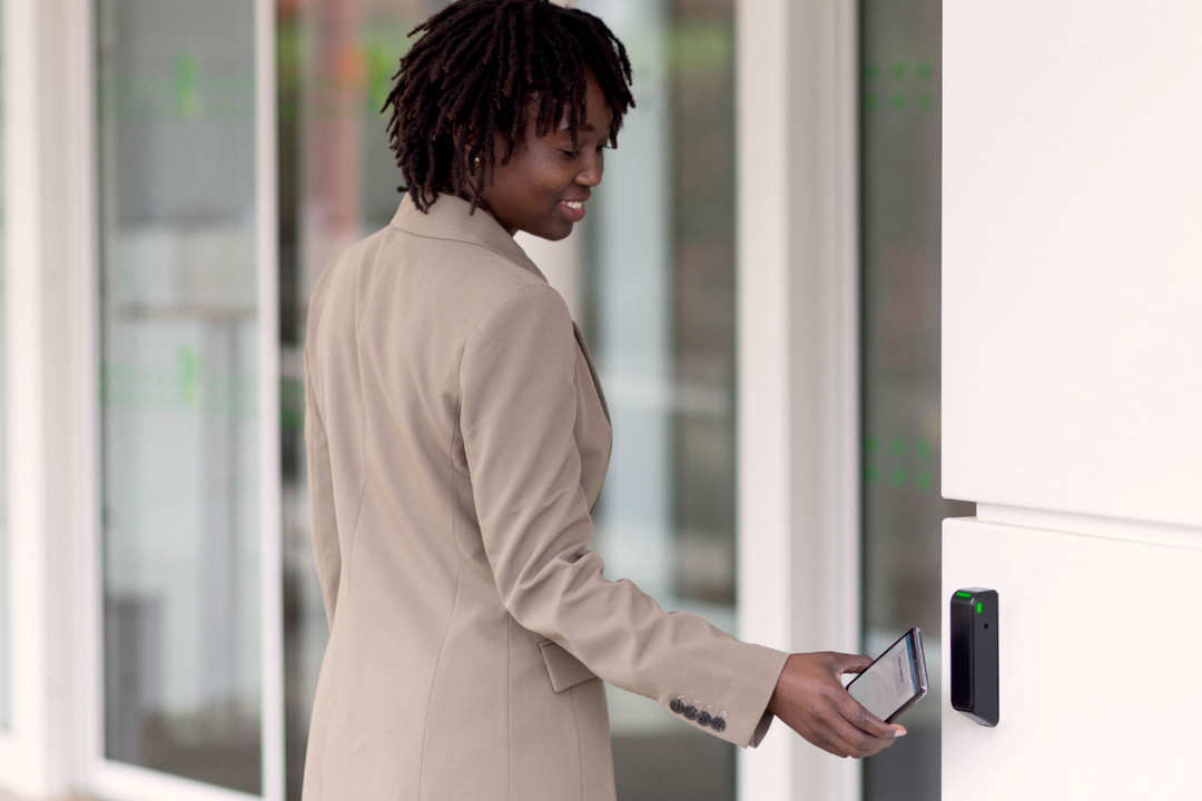Access solution for complex building openings: Card reader from Assa Abloy with integrated relay Employee uses Assa Abloy card reader to open a company door