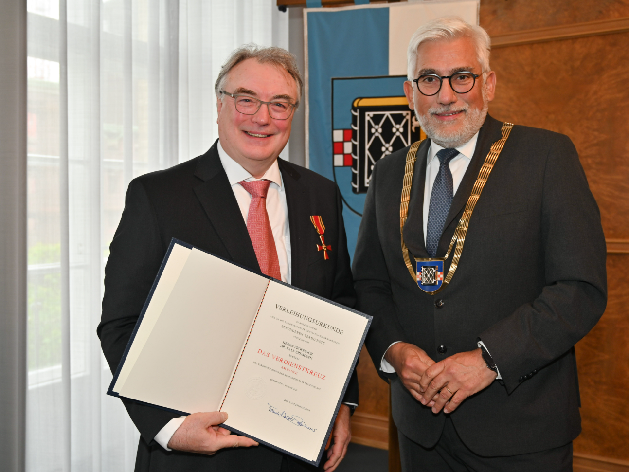 Bundesverdienstkreuz für Ralf Erdmann – Systembiochemiker der Ruhr-Universität Bochum Ralf Erdmann (links) wurde mit dem Bundesverdienstkreuz ausgezeichnet, das ihm Bochums Oberbürgermeister Jörg Lukat (rechts) im Rahmen einer Feierstunde im Rathaus überreichte. Ralf Erdmann (links) wurde mit dem Bundesverdienstkreuz ausgezeichnet, das ihm Bochums Oberbürgermeister Jörg Lukat (rechts) im Rahmen einer Feierstunde im Rathaus überreichte.