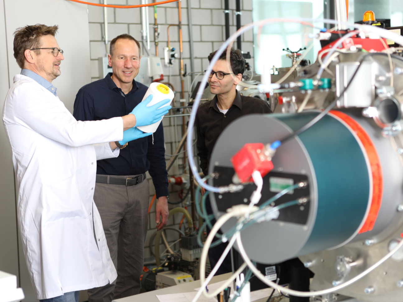 PFAS-freie Textilien: Empa entwickelt nachhaltige Plasma-Beschichtung für Outdoorbekleidung. Wissenschaftler der Empa, die das Plasmatechnologieverfahren zur PFAS-freien Herstellung von Outdoortextilien entwickelt haben am den dafür vorgesehenden Maschinen zur Imprägnierung der Garne. Auf dem Bild Das Empa-Team des Advanced Fibers Labor in St. Gallen : Martin Amberg, Dirk Hegemann und Patrick Rupper (v.l.n.r.).