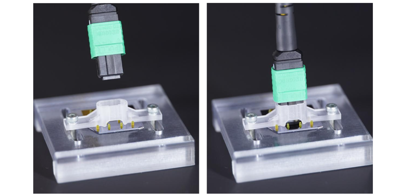 Forschung: Wie ein 3D-System photonische Chips industriefähig macht Die Kameraaufnahme zeigt, wie ein Glasfaserkabel an einen photonischen Chip angeschlossen wird. Eine Vorausrichtungsstruktur trägt das Gewicht des Kabels und Führungsstifte ermöglichen eine sehr präzise Positionierung im Mikrometerbereich.