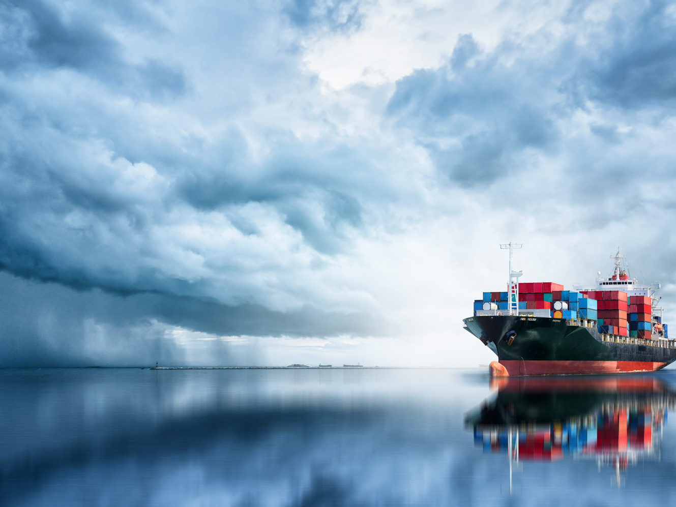 Containerschiff mit dunkel bewölktem Himmel