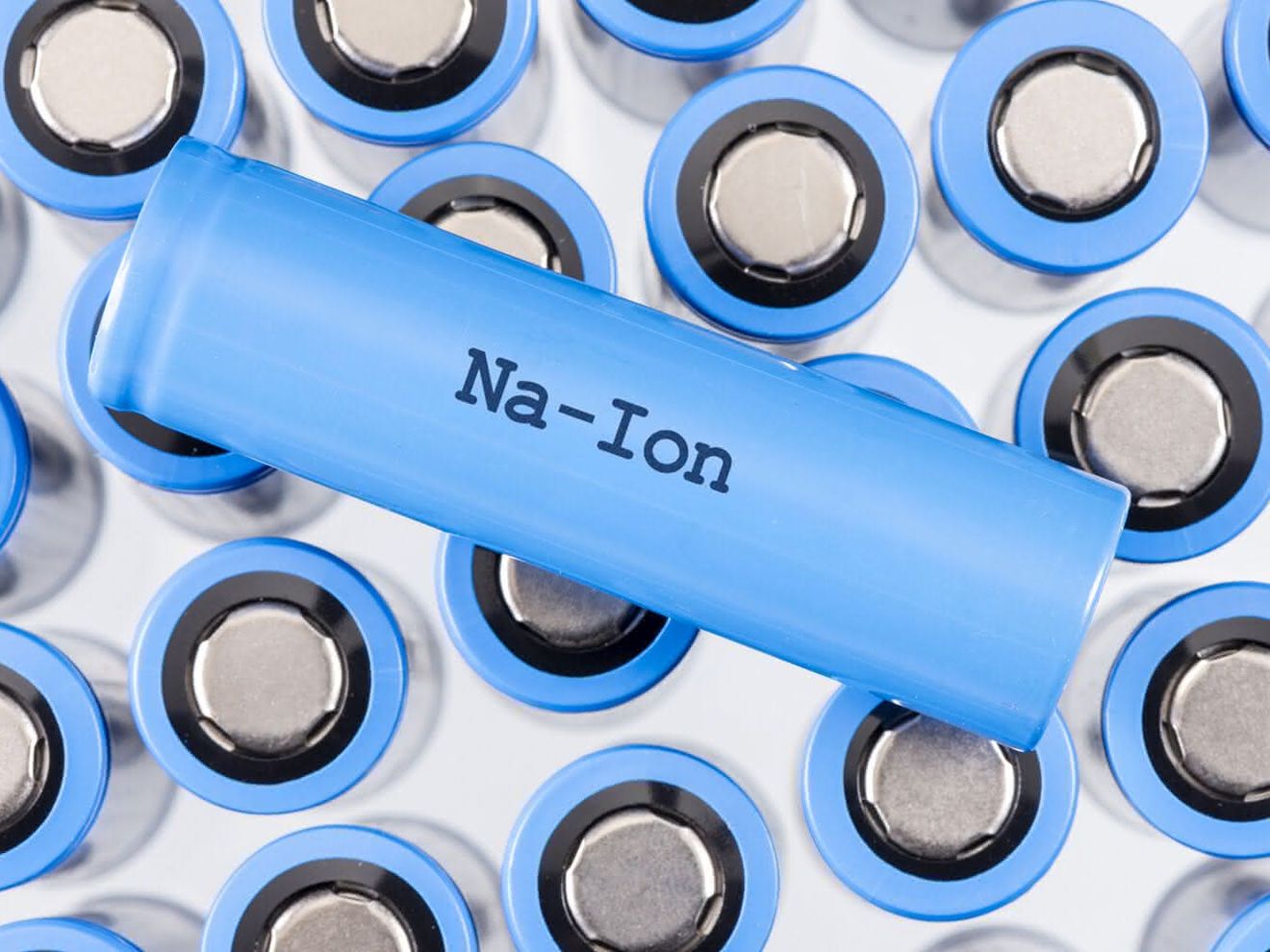 Batterieforschung: Sind Natrium-Ionen-Batterien sicher genug? Viele blaue Natrium-Ionen Batterien, die aufrecht stehen. Darauf liegt quer eine Batterie mit der Aufschrift Na-Ion