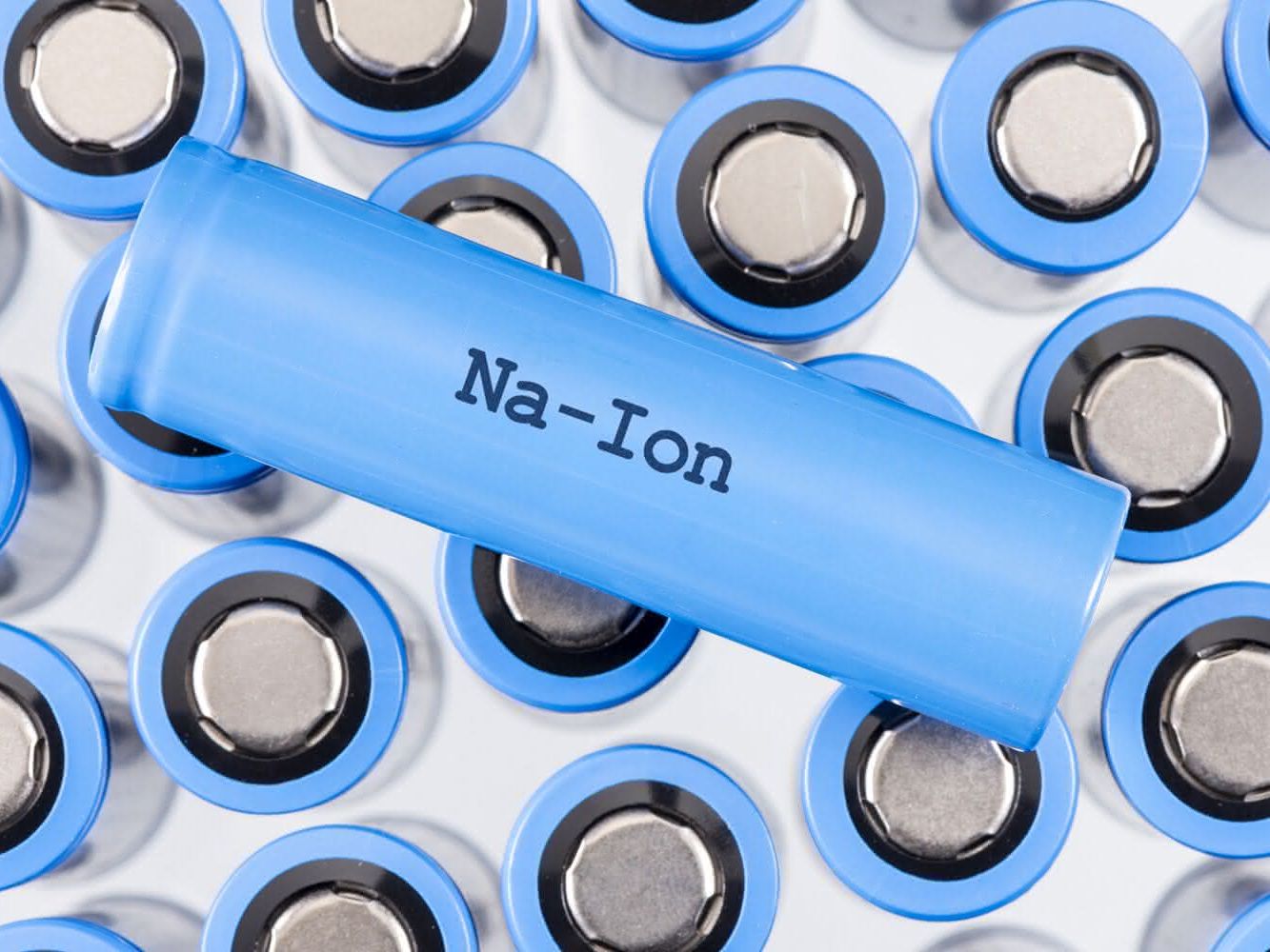 Viele blaue Natrium-Ionen Batterien, die aufrecht stehen. Darauf liegt quer eine Batterie mit der Aufschrift Na-Ion