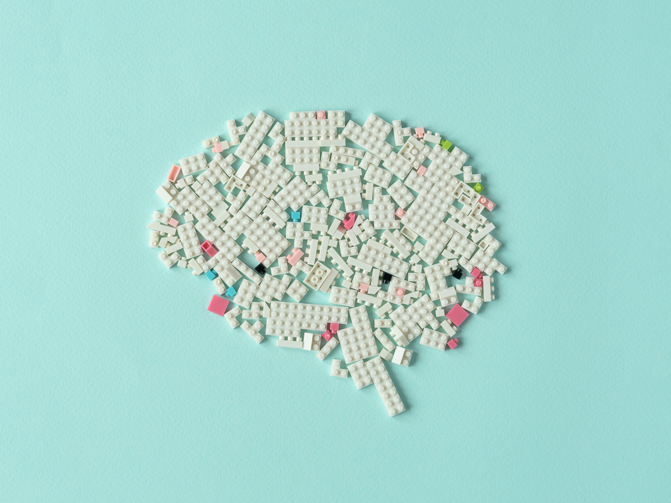 Kann sich das Gedächtnis bei Alzheimer teilweise erholen? Symbolbild Alzheimer: Legosteine in die Form eines Gehirns gelegt. Weiß auf hellem türkisfarbenem Hintergrund