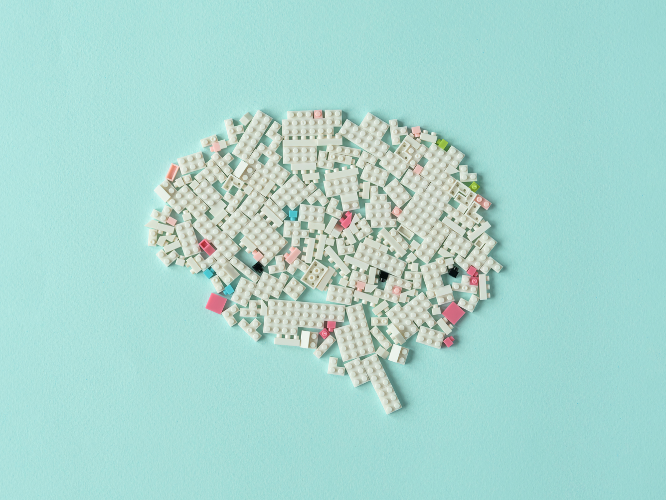 Kann sich das Gedächtnis bei Alzheimer teilweise erholen? Symbolbild Alzheimer: Legosteine in die Form eines Gehirns gelegt. Weiß auf hellem türkisfarbenem Hintergrund