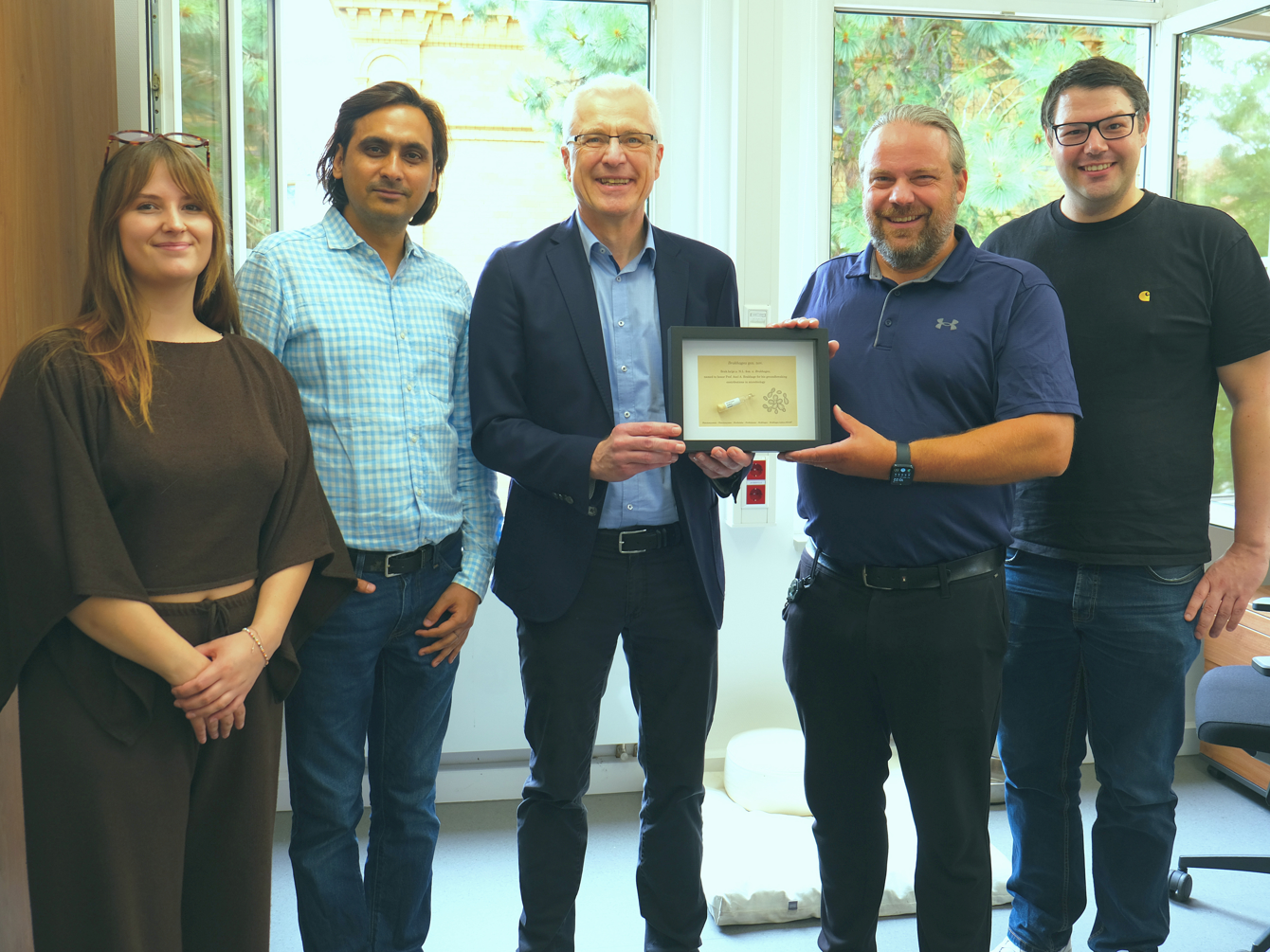 Neue Bakteriengattung Brakhagea beschrieben Zu Besuch im Jogler Lab: Der Namensgeber erhält von Joglers Team eine persönlich gestaltete Urkunde. Zu sehen sind (v. l.) Madeleine Kündgen, Dr. Gaurav Kumar, Prof. Axel Brakhage, Prof. Christian Jogler und Dr. Nicolai Kallscheuer.