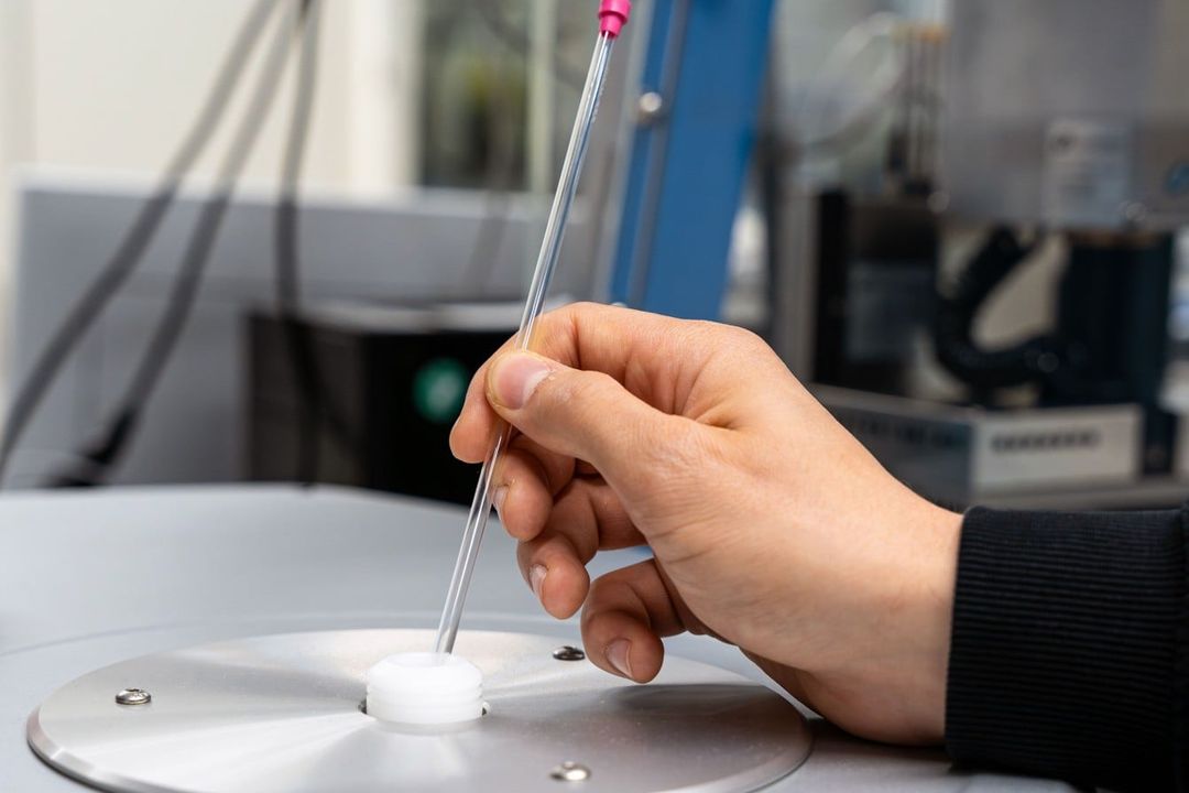 Das Glasröhrchen mit der Probe wird in ein NMR-Spektrometer eingeführt. Das Glasröhrchen mit der Probe wird in ein NMR-Spektrometer eingeführt.