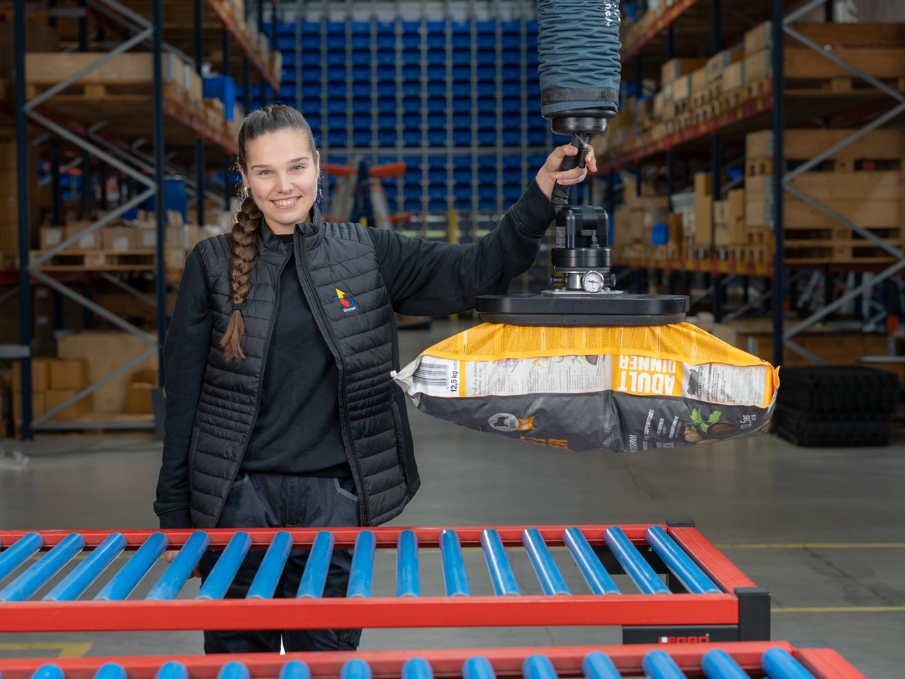 Ergonomisches Handling in der Industrie am Beispiel der Tierfutter-Logistik Mitarbeiterin nutzt quickLIFT von Timmer für Pick-and-Place-Handling.