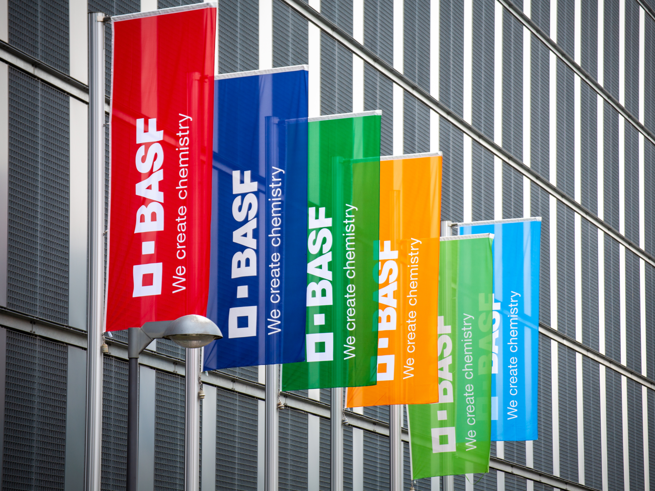 Quartalszahlen BASF Q2 2025 Symbolbild Firmenlogo BASF Firmenlogo auf Flaggen am Betriebsgebäude