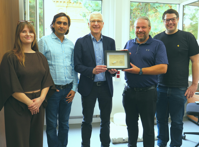Zu Besuch im Jogler Lab: Der Namensgeber erhält von Joglers Team eine persönlich gestaltete Urkunde. Zu sehen sind (v. l.) Madeleine Kündgen, Dr. Gaurav Kumar, Prof. Axel Brakhage, Prof. Christian Jogler und Dr. Nicolai Kallscheuer.
