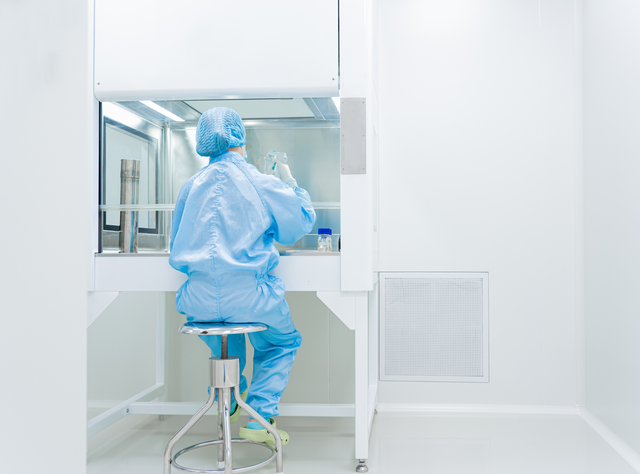 VDI-Richtlinien zur Reinraumtechnik Labormitarbeiterin im Reinraum an einem Labortisch