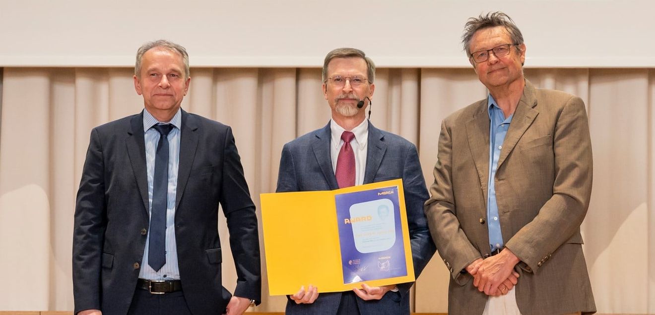 Ulrich Betz und Professor Felix Hausch vom Fachbereich Chemie der TU Darmstadt überreichten Craig M. Crews Auszeichnung Ulrich Betz und Professor Felix Hausch vom Fachbereich Chemie der TU Darmstadt überreichten Craig M. Crews die Auszeichnung