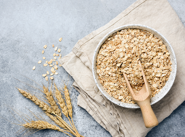 Haferflocken gegen Cholesterin: Zwei-Tages-Kur senkt LDL-Werte erheblich und langfristig Haferflocken und eine Ähre auf dem Tisch als Symbolbild für Artikel: Haferflocken gegen Cholesterin: Zwei-Tages-Kur senkt LDL-Werte erheblich und langfristig