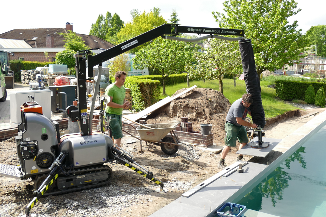 Eine neue Pflasterverlegemaschine PaveJet S24 im Einsatz auf der Baustelle eines Pools