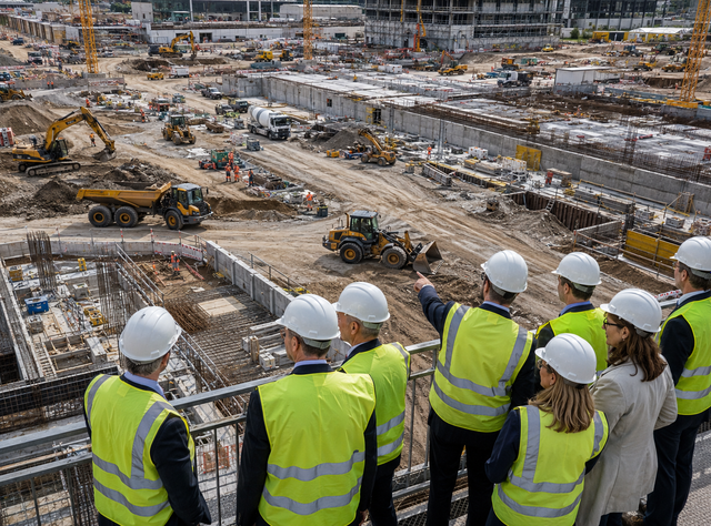 Weibliche und männliche Politiker blicken auf eine Baustelle