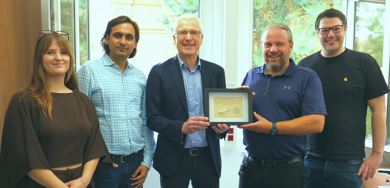 Neue Bakteriengattung Brakhagea beschrieben Zu Besuch im Jogler Lab: Der Namensgeber erhält von Joglers Team eine persönlich gestaltete Urkunde. Zu sehen sind (v. l.) Madeleine Kündgen, Dr. Gaurav Kumar, Prof. Axel Brakhage, Prof. Christian Jogler und Dr. Nicolai Kallscheuer.