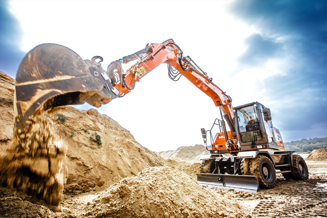 Ein neuer Mobilbagger 185W entlädt Sand aus seinem großen Baggerlöffel