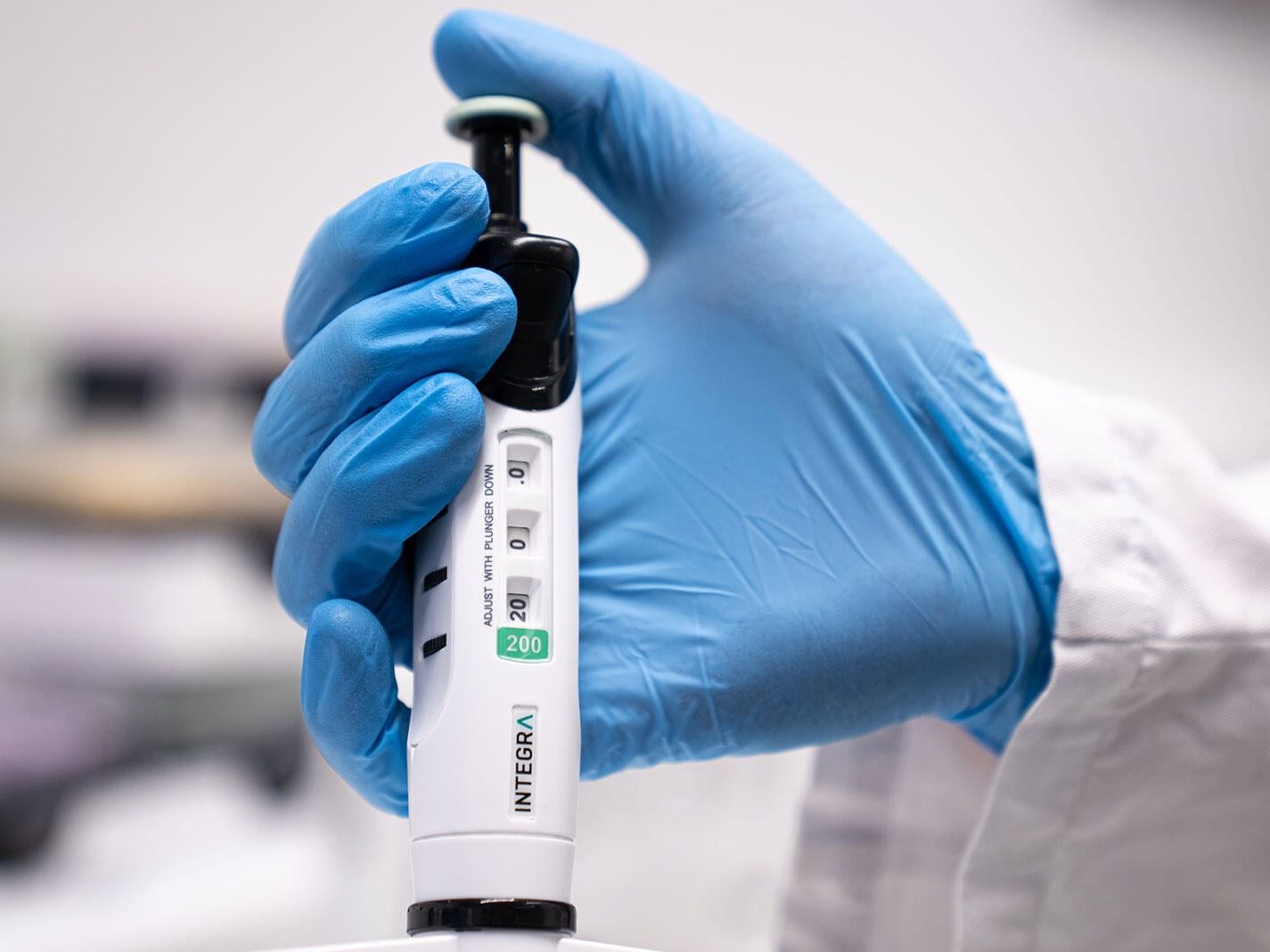 Ergonomisches Pipettieren EVOLVE-Pipette von Integra in der Hand eines Labor-Mitarbeitenden