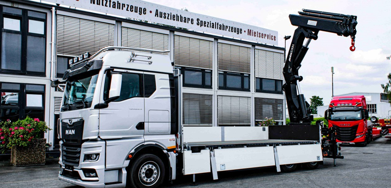 Neben Lkw und Sattelzugmaschinen präsentiert ES-GE auch Anhänger und Satteltieflader der eigenen Marke sowie Auflieger von MAX Trailer. Ein Ladekran von ES-GE Nutzfahrzeuge vor der eigenen Werkshalle
