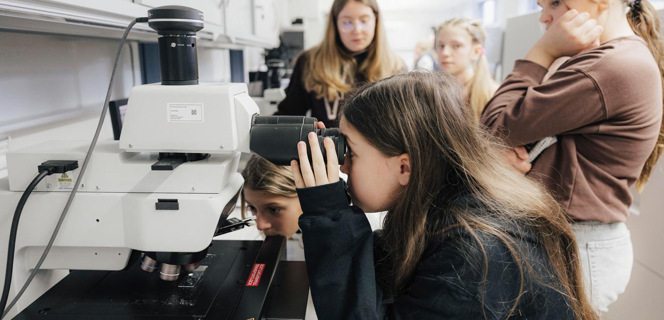 Mit dem Lichtmikroskop am Fraunhofer IISB verfolgen Schülerinnen der Montessori Schule Herzogenaurach in Echtzeit das Wachstum von Mikrokristallen aus einer gesättigten KaliAlaun-Lösung.