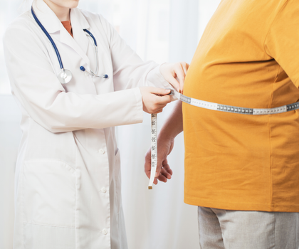 Gewicht halten nach Abnehmspritzen: Ärztin misst Bauchumfang mit einem Maßband bei einem Patienten, der wegen Übergewicht mit der Abnehmspritze behandelt wurde