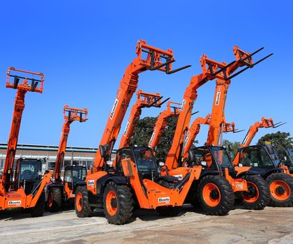 Boels Rental und Cramo starten digitalen Marktplatz Teleskolader von Boels mit der typischen orangen Lackierung auf einem Werksgelände